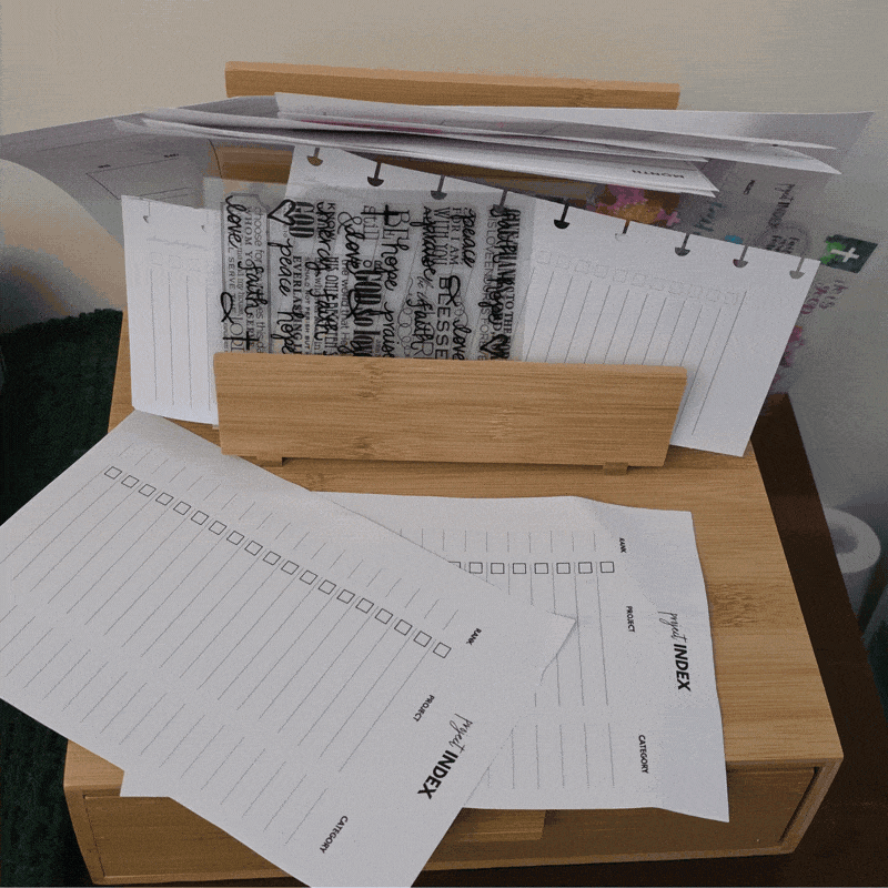 GIF showing a desk organizer with a jumble of loose planner pages, inserts and stickers that are falling all over the place and getting wrinkled. Then it changes to another view of the same desk organizer with DIY Storage Pockets to hold all those items neatly and safely.